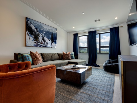Sink into plush seating and let your gaze drift across sweeping views beyond the windows. This inviting living space blends comfort with natural beauty, perfect for your mountain getaway.