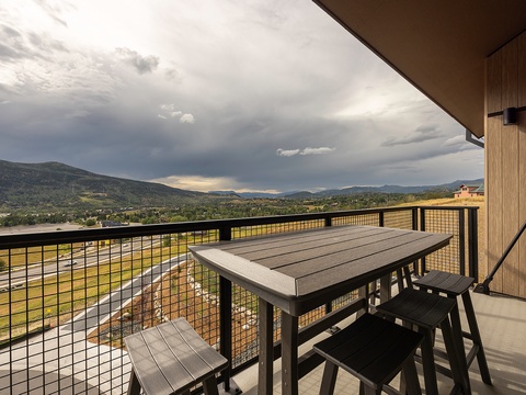 Stunning mountain views stretch across the horizon as you enjoy your morning coffee on this private balcony, where dramatic skies and rolling hills create a breathtaking backdrop for your stay.