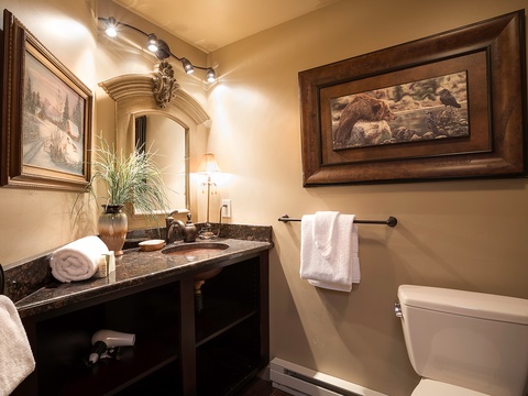 Step into your private bathroom featuring granite countertops, plush towels, and warm lighting that creates a cozy, spa-like atmosphere for your mountain getaway.