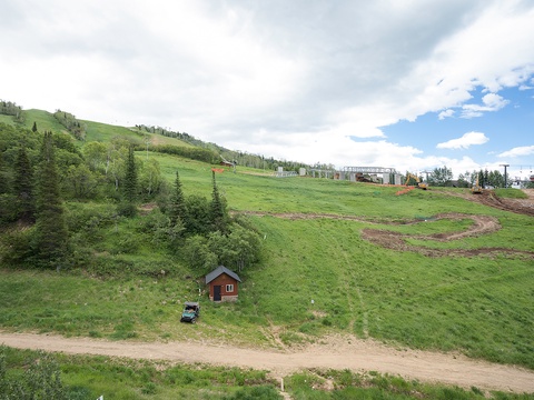 Alpine property nestled on lush hillside with ski lift access and expansive mountain terrain, offering year-round outdoor recreation and serene natural surroundings.