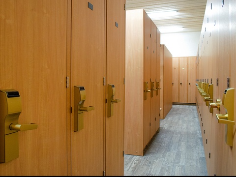 A well-organized locker room with secure storage awaits, featuring modern wood-toned lockers with electronic keyless entry systems for your convenience and peace of mind.