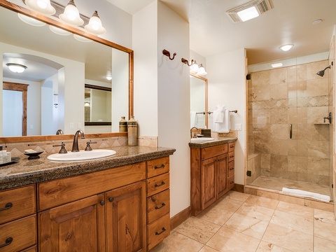 Step into your private spa-like retreat with dual vanities, elegant granite counters, and a spacious walk-in shower framed in glass—perfect for unwinding after a day of adventure.