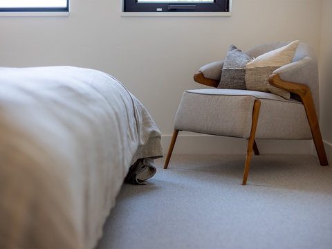 Sink into the plush reading chair with soft pillows and let natural light fill your peaceful bedroom retreat.