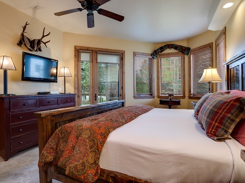 Unwind in your cozy bedroom with rustic charm, featuring a plush bed, warm lighting, and mountain-inspired decor. Your peaceful retreat awaits with modern comforts and natural ambiance.