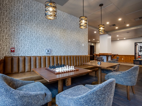Unwind in this stylish communal lounge, featuring a chess set ready for your next match, cozy seating, and modern lighting that creates the perfect ambiance for relaxing evenings.