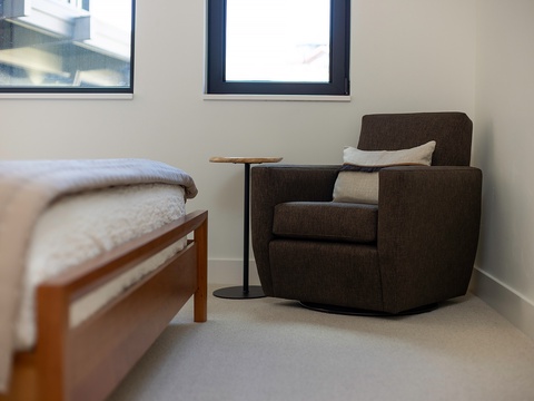 Curl up in your cozy reading chair by the window, where soft natural light and plush bedding create the perfect retreat after a day of exploring.