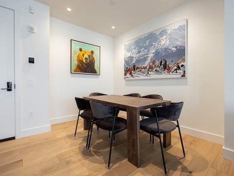 Gather around this inviting dining table where your group can share meals and stories. The warm wood tones and modern chairs create a cozy space perfect for morning coffee or evening conversations.