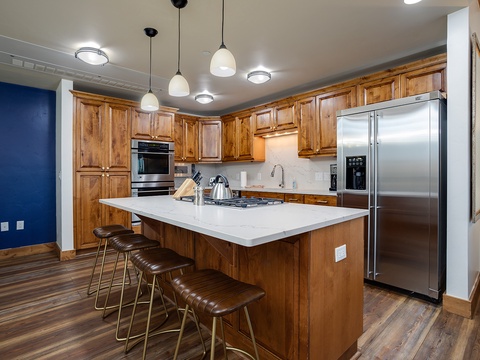 Picture yourself preparing your favorite meal in this bright, spacious kitchen with gleaming stainless appliances, warm wood cabinetry, and a large island perfect for gathering around morning coffee.