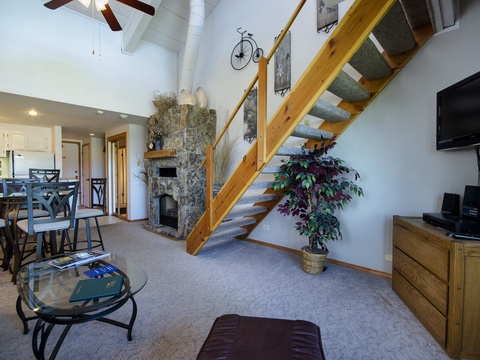 Unwind in your bright, two-story retreat with soaring ceilings, a stone fireplace, and airy open layout connecting living, dining, and kitchen spaces—your cozy mountain escape awaits.
