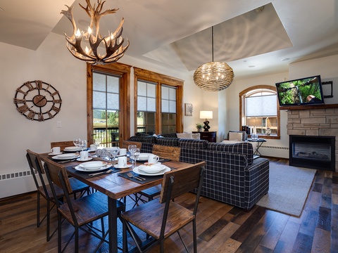 Gather around the dining table while natural light pours through wooden-framed windows, or unwind by the fireplace in your cozy living area with mountain views beckoning beyond.