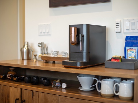 Your morning ritual awaits with a sleek espresso maker, fresh beans, and handpicked mugs ready to brew that perfect cup in your home away from home.