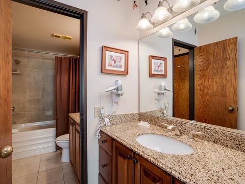 Your private bathroom features a spacious granite vanity, walk-in shower-tub combo, and charming artwork that makes freshening up feel like home.