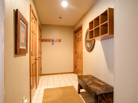 Your welcoming entryway features warm wood accents, thoughtful storage cubbies for gear, and a cozy bench where you can relax as you prepare for your mountain adventures.