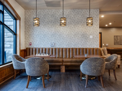 Gather around this stylish communal lounge featuring plush seating, modern lighting, and warm wood accents perfect for your relaxation or socializing during your stay.