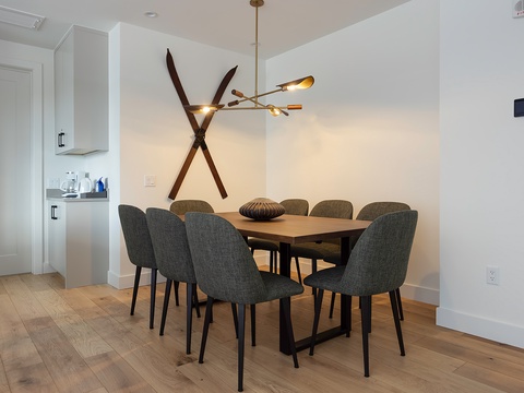 Gather around this sleek dining table under stylish modern lighting—perfect for your morning coffee or evening dinner with friends.