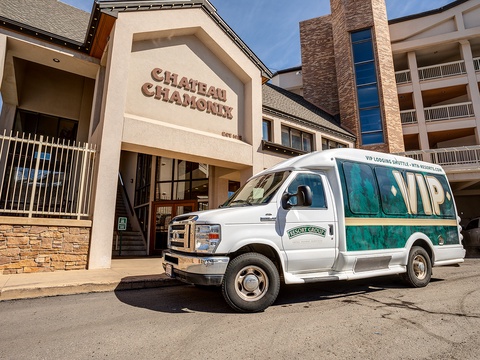 The Chateau Chamonix resort entrance stands alongside a VIP shuttle van ready to transport guests, offering convenient access to nearby attractions and lodging in the area.