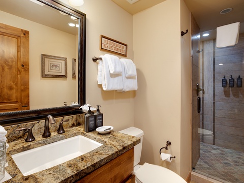 Unwind in your beautifully appointed bathroom featuring granite countertops, plush towels, and a spacious walk-in shower with premium amenities for your comfort.