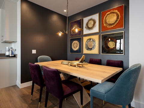 Striking dining space featuring a rich charcoal wall, warm wood table, and jewel-toned velvet chairs. Perfect for memorable meals and lingering conversation.