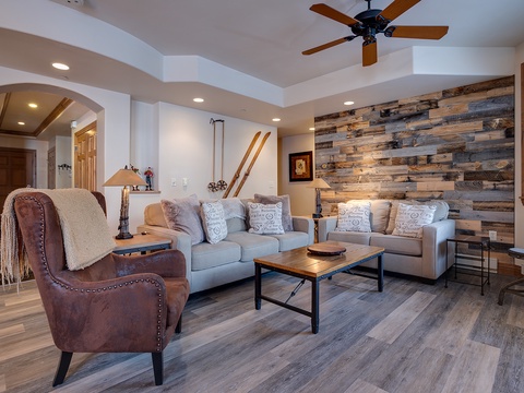 Relax in your inviting living room with vaulted ceilings, rustic wood accent wall, and comfortable seating—perfect for unwinding after exploring the area.