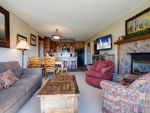 Your welcoming retreat features cozy fireside seating and an open layout connecting the living space to your well-equipped kitchen—perfect for relaxing evenings after mountain adventures.