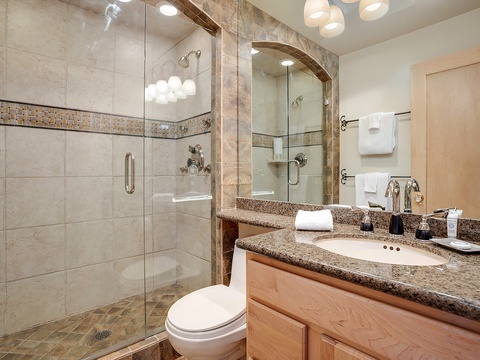 Step into your spa-inspired bathroom with a spacious walk-in shower, elegant granite countertops, and plush towels waiting for you after a refreshing rinse.