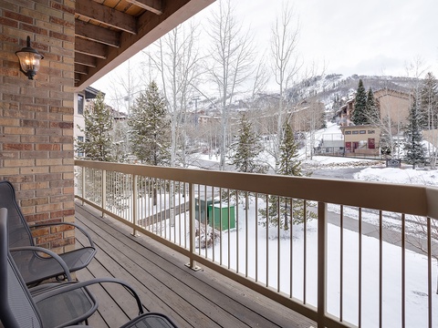 A scenic winter mountain vista framed by bare aspen trees and evergreens, with snow-covered slopes and neighboring ski resort buildings creating the quintessential alpine backdrop for this property.