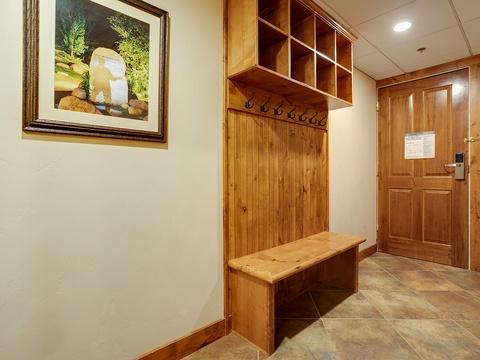 Spacious entryway with custom wooden storage bench, coat hooks, and cubbies—perfect for stowing your gear after mountain adventures.