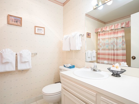 Your private bathroom features fresh white linens, a well-lit vanity with plenty of counter space, and a peaceful atmosphere that makes unwinding after a day of exploring feel effortless.