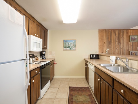 Your fully equipped kitchen features warm wood cabinetry, modern appliances, and ample counter space—perfect for preparing meals during your mountain getaway.