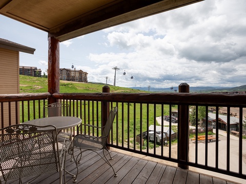 A covered balcony frames sweeping mountain views and a scenic gondola gliding overhead, perfect for morning coffee or evening relaxation in the fresh alpine air.