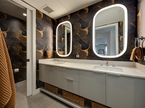 Discover your private spa-like retreat with dual illuminated mirrors, elegant wallpaper, and a spacious vanity designed for relaxation and rejuvenation.