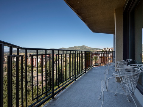 A private balcony offering panoramic mountain and neighborhood views, featuring outdoor seating perfect for morning coffee or evening relaxation.