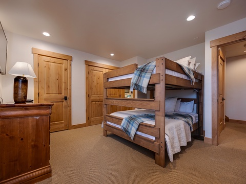 Rustic charm meets comfort in this cozy bunk room, where handcrafted wood furniture and plaid accents create your perfect mountain retreat for restful nights after adventure-filled days.