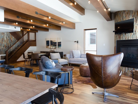 Relax in this spacious lounge with soaring beamed ceilings, warm fireplace, and stylish leather and upholstered seating—your perfect spot to unwind after a mountain adventure.