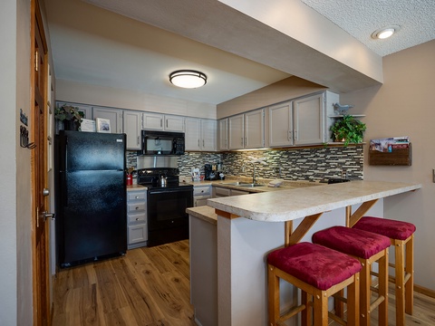 Your fully equipped kitchen features modern appliances, elegant backsplash, and a breakfast bar where you can savor morning coffee with family or prep meals together.
