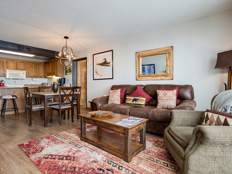 Picture yourself unwinding on plush sofas after a day of adventure, warm lighting casting a cozy glow across this inviting open-concept space where you can cook, dine, and relax together.