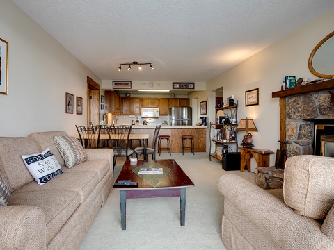 Relax in your cozy open-concept living space with plush seating, warm fireplace, and fully equipped kitchen—perfect for unwinding after mountain adventures.