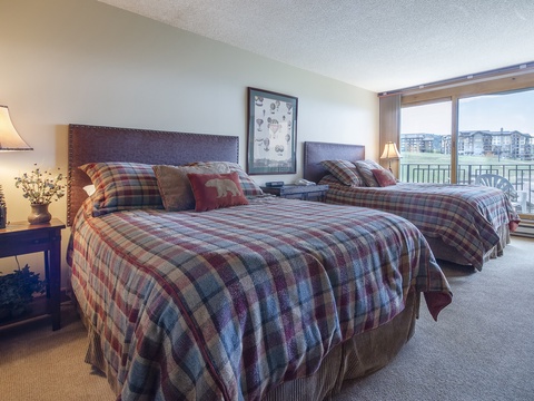 Sink into plaid-covered beds and wake to mountain views framed by your private balcony—this cozy alpine retreat is ready for you and your travel companions to unwind in style.