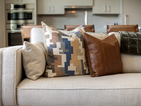 Sink into soft, textured cushions as you unwind in this open-concept space, where the living room flows effortlessly into a sleek, modern kitchen ready for your culinary adventures.