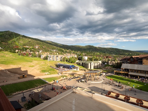 A mountain village nestled in forested hills, featuring a community playground and recreational areas in the surrounding neighborhood.
