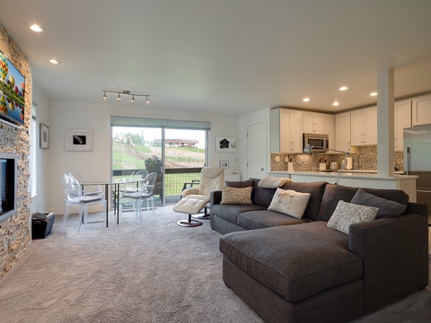 Unwind in your open-concept living space where a plush sectional invites movie nights by the fireplace, while your fully-equipped kitchen awaits your culinary adventures and vineyard views inspire relaxation.