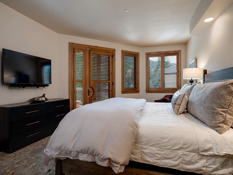 Unwind in your private suite with plush linens, natural light streaming through shuttered doors, and a flat-screen TV for cozy evenings in.