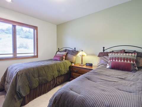 Relax in your comfortable twin bedroom with classic decor, plush linens, and natural light—perfect for restful nights after exploring the area.