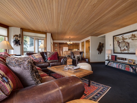 Sink into rich leather sofas under warm wood-paneled ceilings, where rustic artwork and cozy textiles create your perfect mountain retreat for relaxation and togetherness.