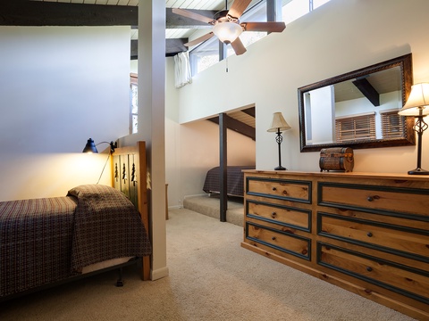 Relax in your spacious bedroom with soaring ceilings, rustic wooden furniture, and a cozy loft sleeping nook—perfect for peaceful mountain getaway nights.