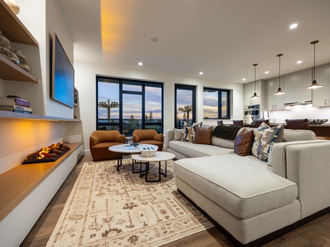 Sink into plush seating and take in the stunning sunset views. Your open-plan living space flows seamlessly into a modern kitchen, perfect for entertaining or quiet evenings in.