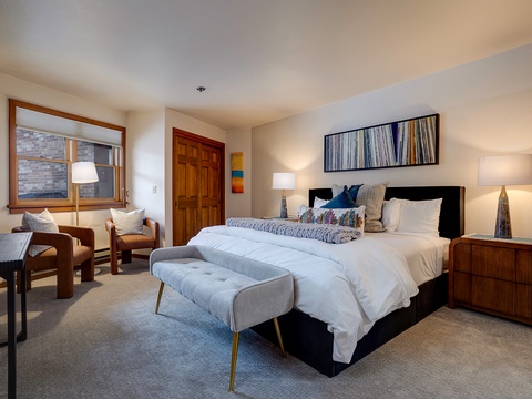 Your serene retreat awaits with plush bedding, modern furnishings, and a cozy seating nook. Thoughtful touches like layered textures and warm lighting create a perfect sanctuary for relaxation after your day's adventures.