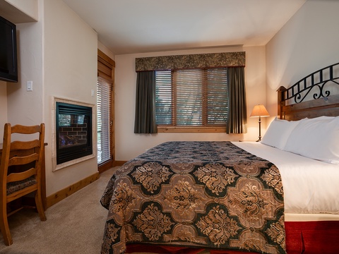 Sink into plush bedding as the fireplace glows warmly beside you, creating your perfect mountain retreat where comfort meets elegance in every detail.