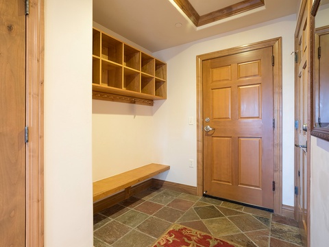 Your private entryway welcomes you with warm wood tones, custom storage cubbies for gear, and a built-in bench—perfect for easy comings and goings.