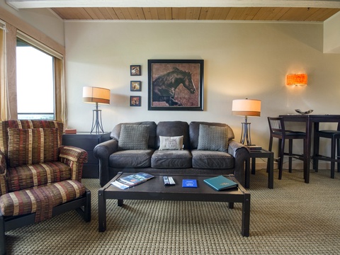 Your spacious living area invites relaxation with plush seating, warm lighting, and thoughtful touches. Unwind on the sofa, enjoy views through large windows, or gather around the dining table for memorable meals together.